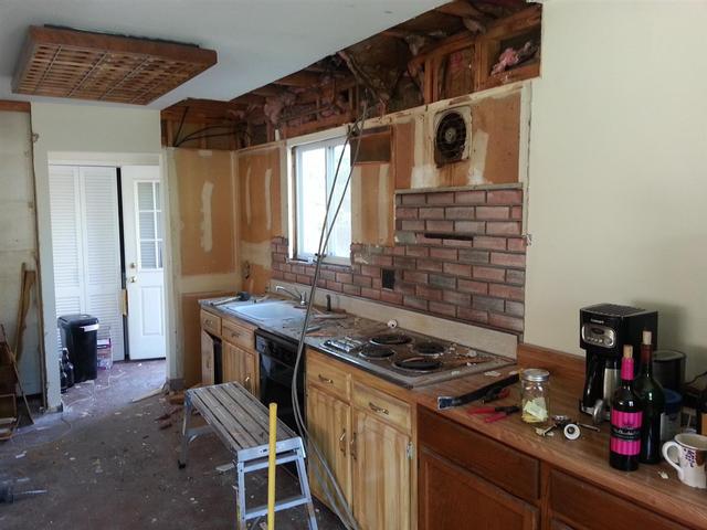 117:  After installing the beam and removing the load bearing wall, we continued on with demo in the kitchen.  We pulled down the wall cabinets, and the soffit above.