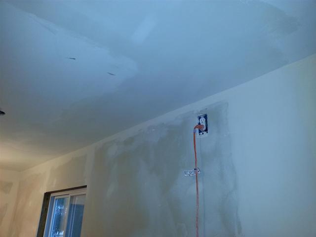 143:  A couple more skim coats got the ceiling faired out pretty well. Its not perfect, but Its about the best I can do without pulling down sheetrock again. The taped corner seams were a little rough, but we cleaned them up with a sanding sponge. Theyll be covered with wallpaper and crown moulding anyway, so I wont worry too much about them.