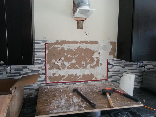 208: Oh, the joys of doing things twice.  Here we are, chipping the first backsplash tile out.  You can see the thinset is pulling chunks of drywall out with it.