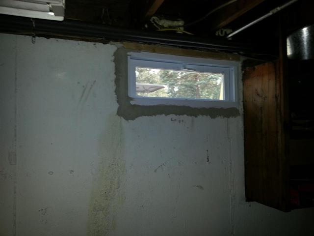 215: There wasnt enough room to frame the windows out, so we simply grouted them in on the bottom and sides.   We did place one 2x4 along the top on two windows where the top cement was removed.  The 2x4 was caulked to the window frame, and then grouted into place against the foundation walls.