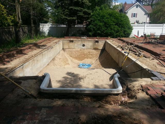 242: The pool liner is almost out, and the stairs have been cut free.  Once I finally pump and shovel out all the decaying crud from the last bit of liner, I can unscrew the main drain faceplate and pull the last bit of liner out.