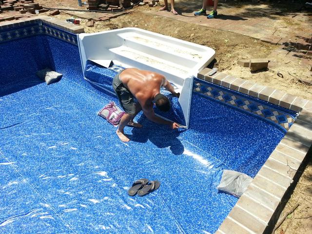 277: Here I am jumping the gun and cutting in the stairs before the water has come up.  I wanted to help create a good vacuum seal, but neglected to realize how much liner would be pulled into the deep end as the pool filled up.  I could have used the extra material.