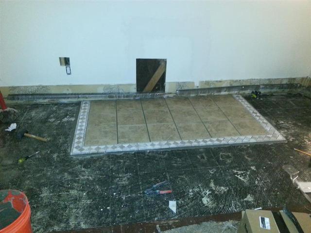 306: The tile for the pellet stove is down, and we cut into the wall to frame out for the vent pipe thimble.