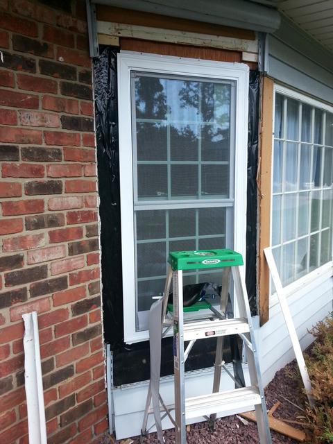 367: Today, we're replacing the windows on either side of the living room bay window.  We pulled back the aluminum fascia, and a little vinyl siding, and pried out the old windows.  Here is the new window in place, and the flashing going up.