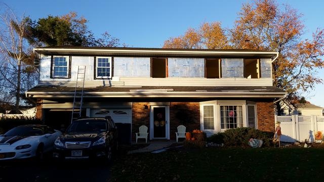 379: My brother Dave came by to give me a hand.  Once he got here, things went much faster.  Thanks Dave!  We pried out all five windows, cleaned up the rough openings, and hung the first two windows.  As daylight faded, we got the rest of the holes in the house filled with glass.  We finished the flashing just in time before it got too dark to be up on a roof.