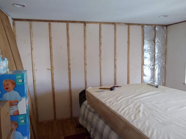 460: First order of business was to remove the paneling.   Under that was a very thin layer of insulation, and furring strips.  