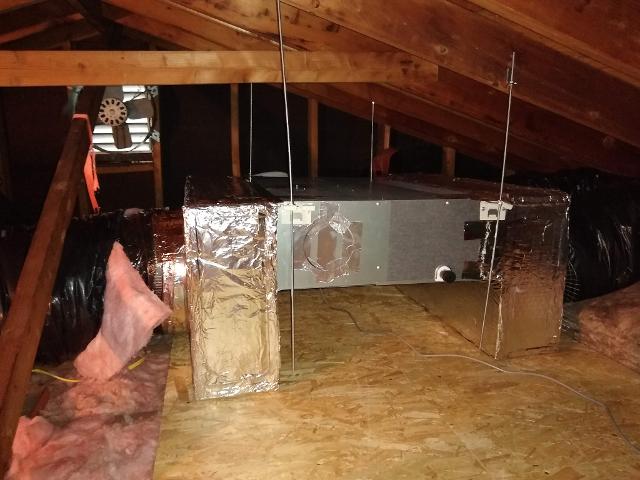 397: Air handler is fully installed in the attic, with both the supply and the return duct manifolds affixed.